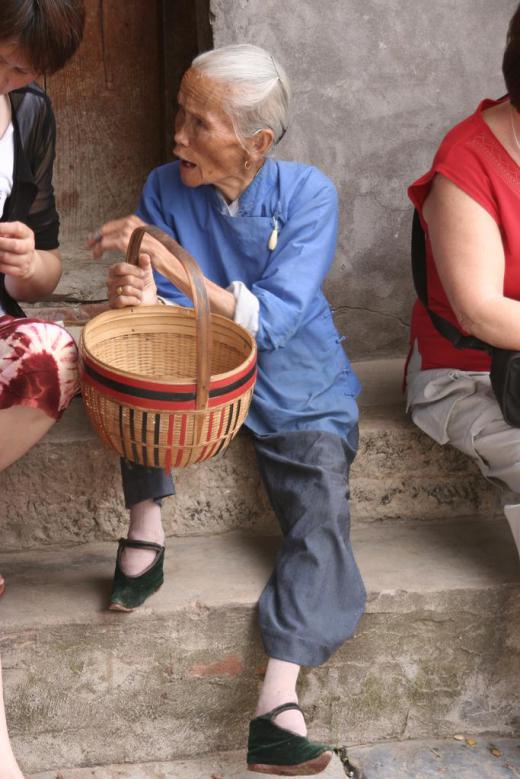 An elderly lady with bound feet.